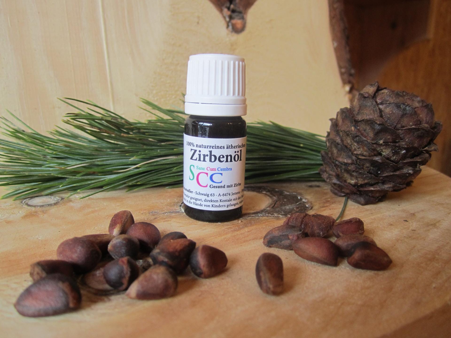 Flasche naturreines ätherisches Zirbenöl mit Zirbenzapfen und Zirbennadeln